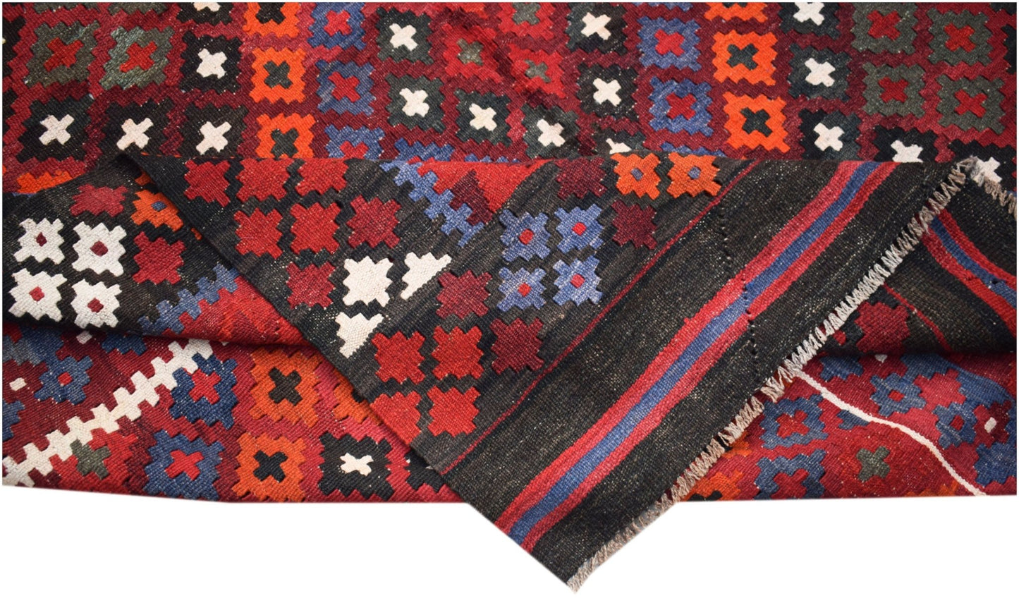 A handmade Afghan Maimana kilim featuring a geometric pattern in red, blue, and white wool.