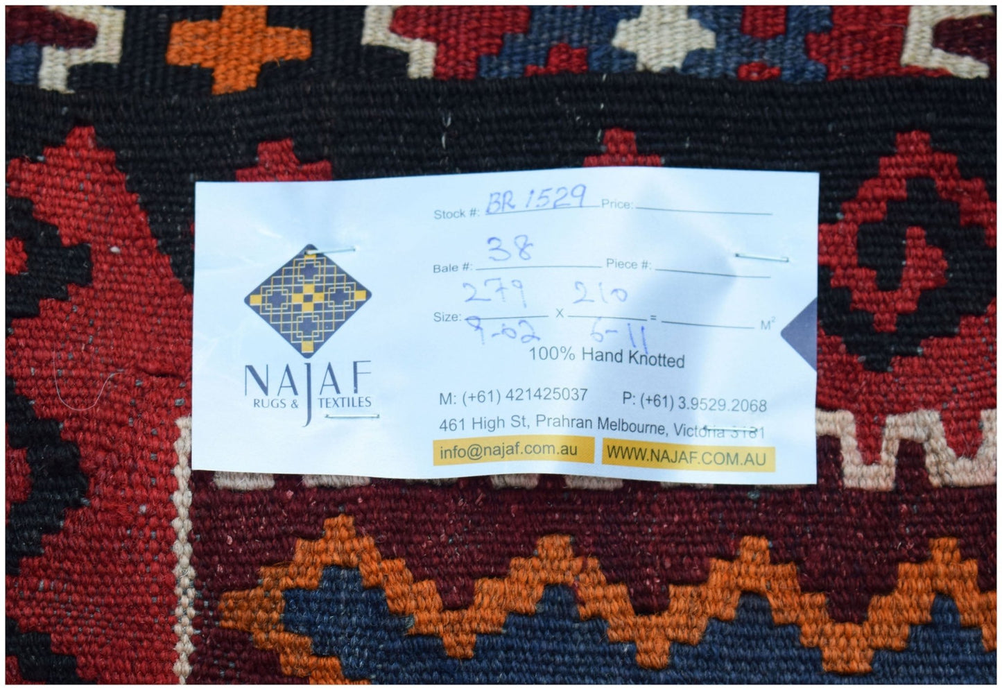 A handwoven Afghan Maimana kilim featuring a geometric pattern in red, blue, and orange wool.