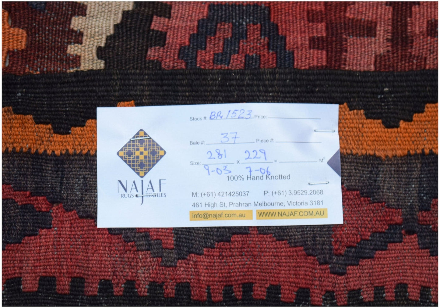A handmade Afghan Maimana kilim featuring a geometric pattern in shades of red, orange, and black.