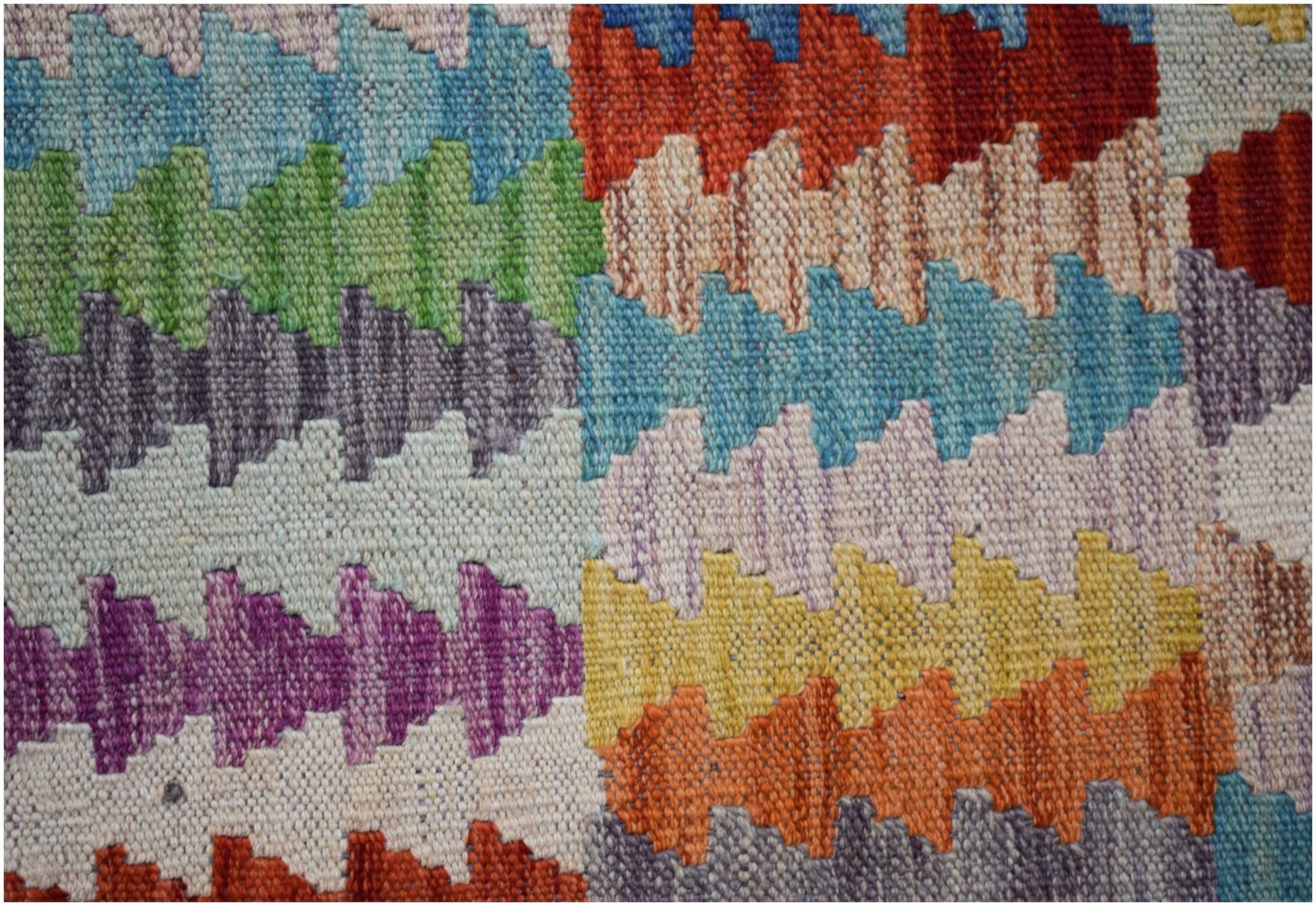 Handwoven Afghan Maimana kilim featuring a vibrant, multicolored geometric pattern.