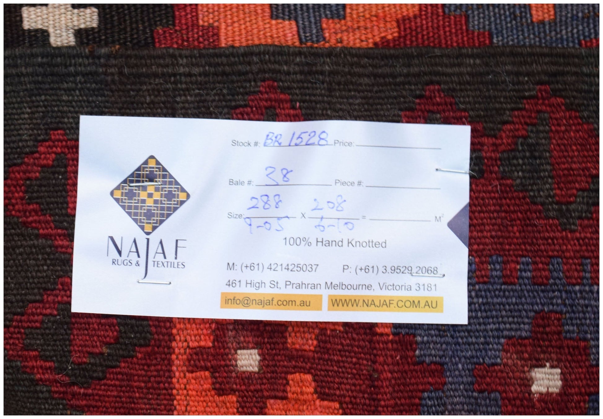 A handwoven Afghan Maimana kilim featuring a geometric pattern in shades of red, blue, and black.