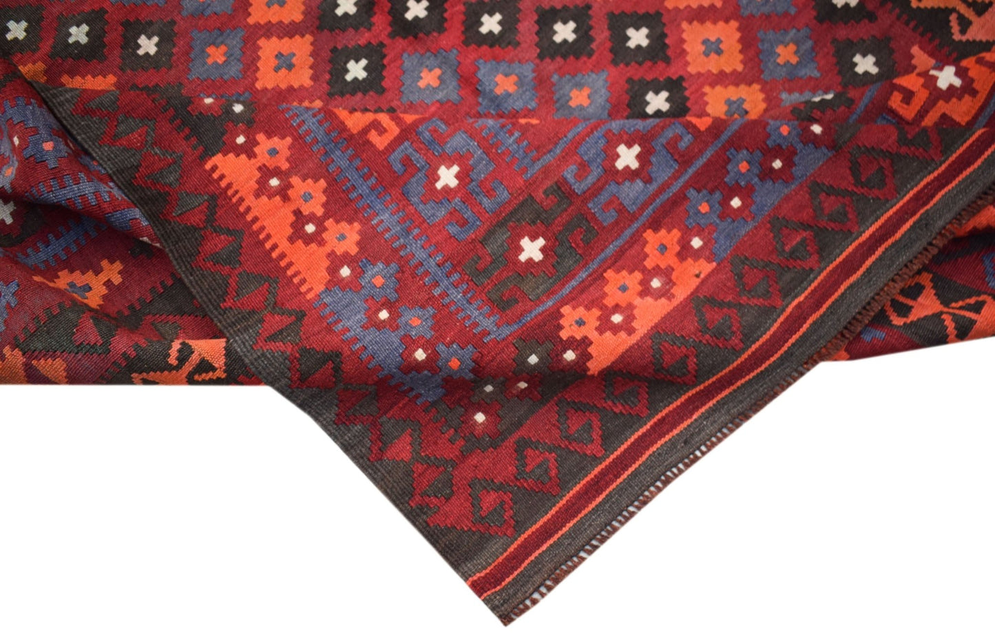 A handmade Afghan Maimana kilim rug featuring a geometric pattern in red, blue, and black wool.