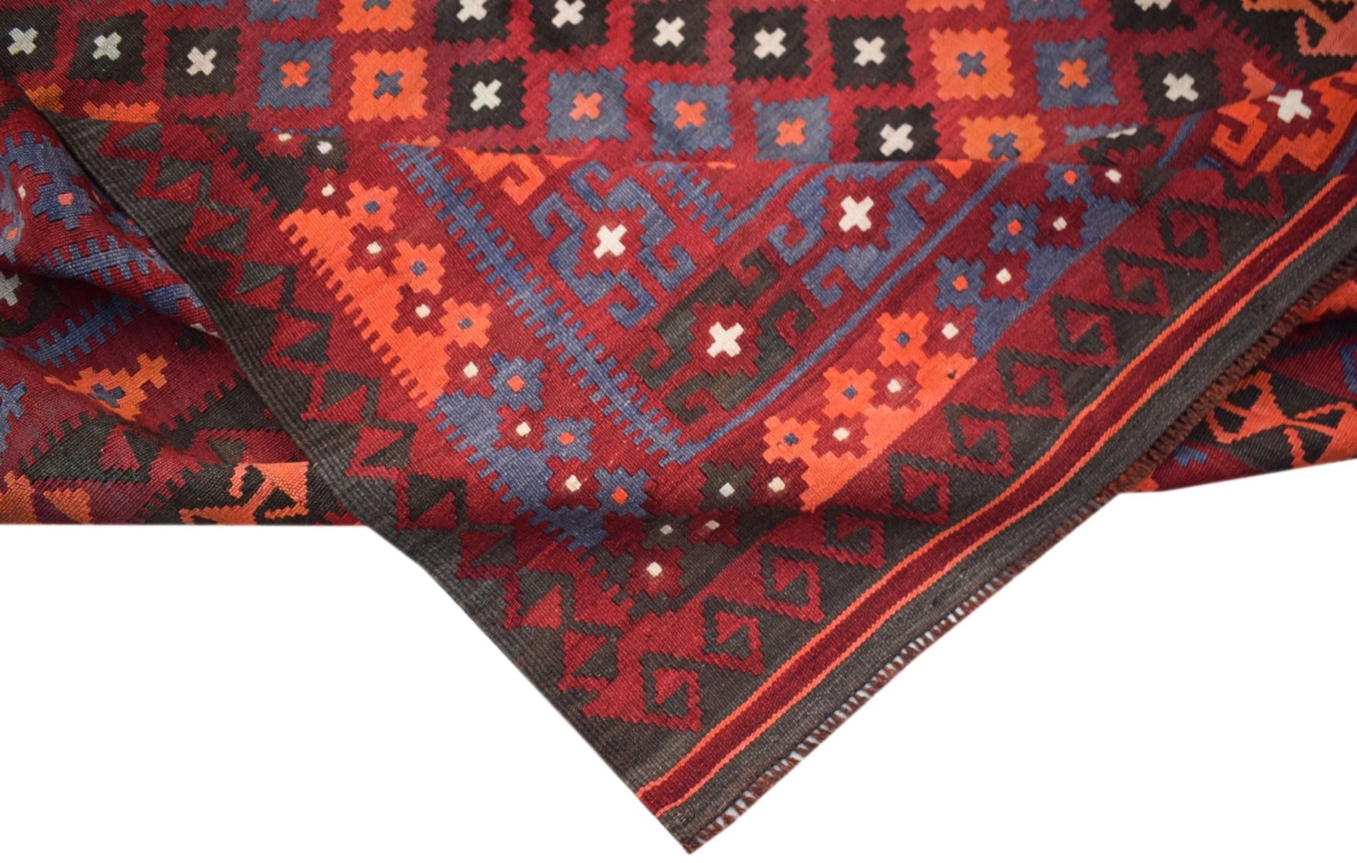 A handmade Afghan Maimana kilim rug featuring a geometric pattern in red, blue, and black wool.
