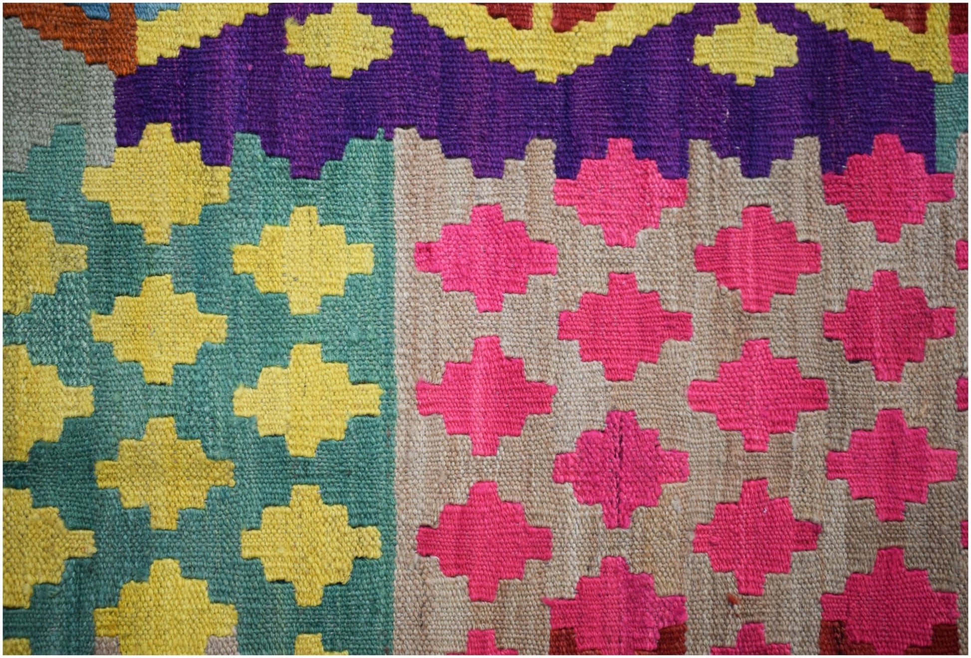 Handwoven Afghan Maimana kilim featuring a geometric pattern of yellow and pink cross motifs.