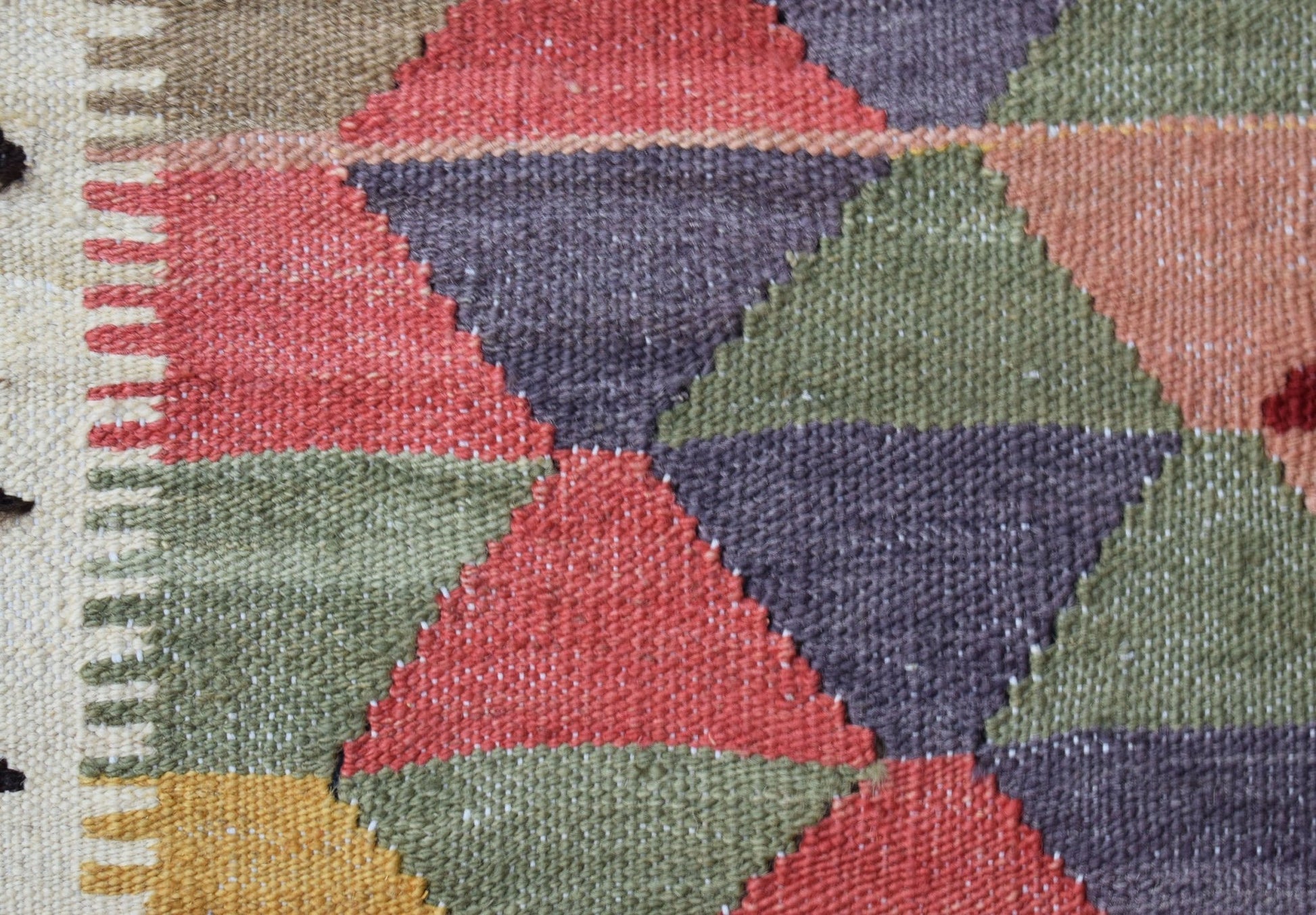 A close-up of a handmade Afghan Maimana kilim featuring a geometric pattern in wool.