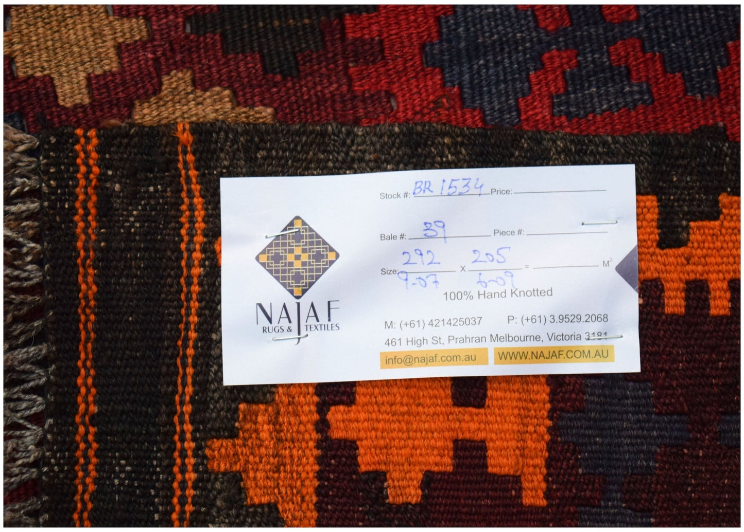 A handwoven Afghan Maimana kilim featuring a geometric pattern in orange, red, and dark brown.