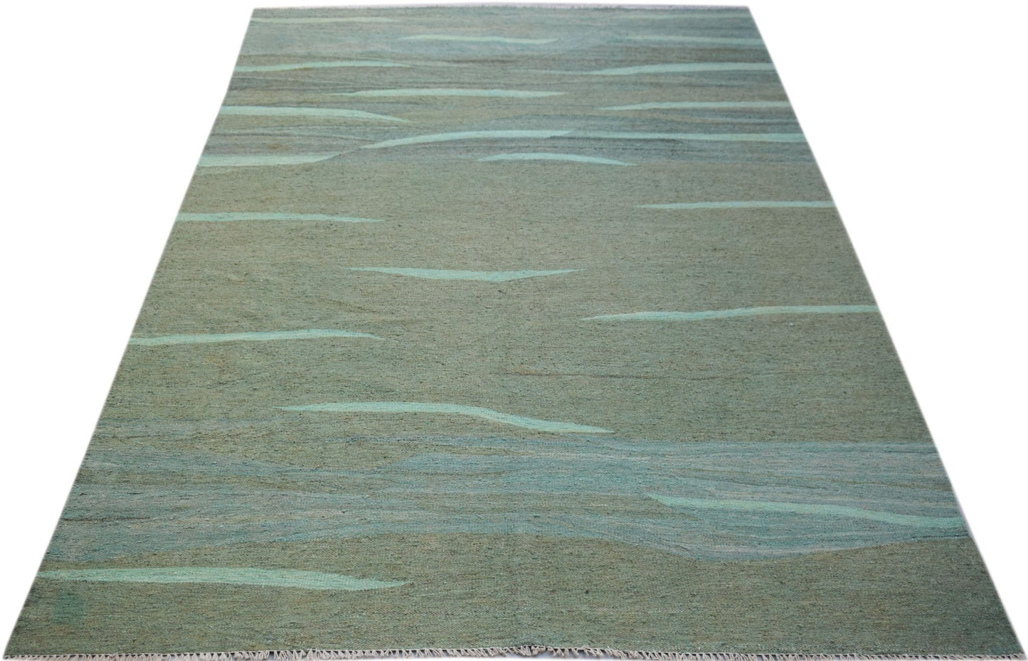 A handmade Afghan Maimana kilim rug featuring an abstract, wavy pattern in shades of green and blue.