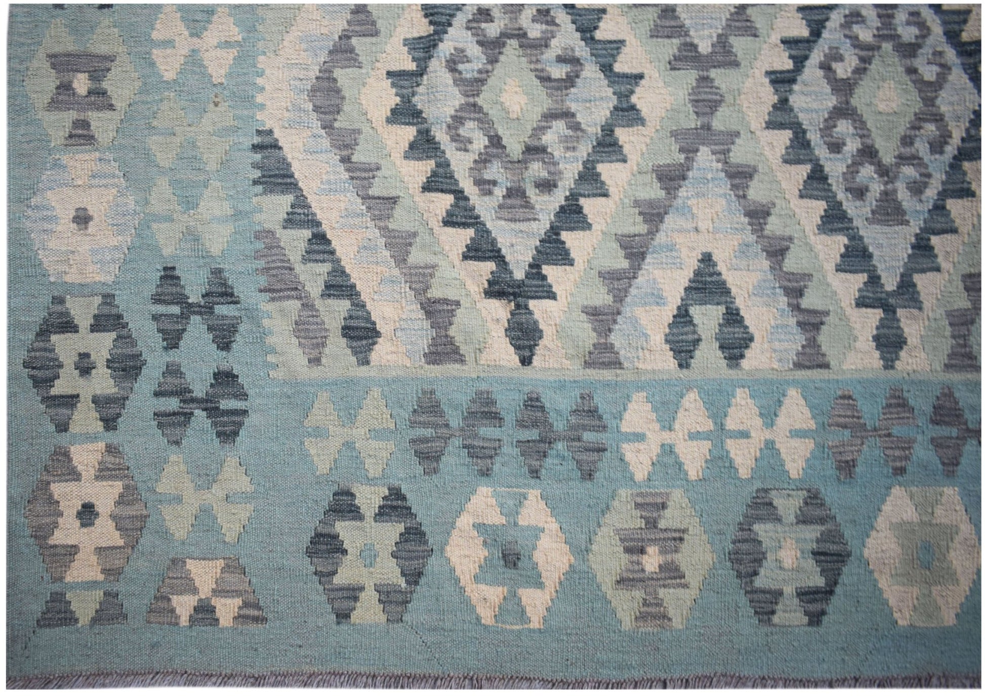 Handwoven Afghan Maimana kilim rug featuring geometric patterns in shades of blue and cream.