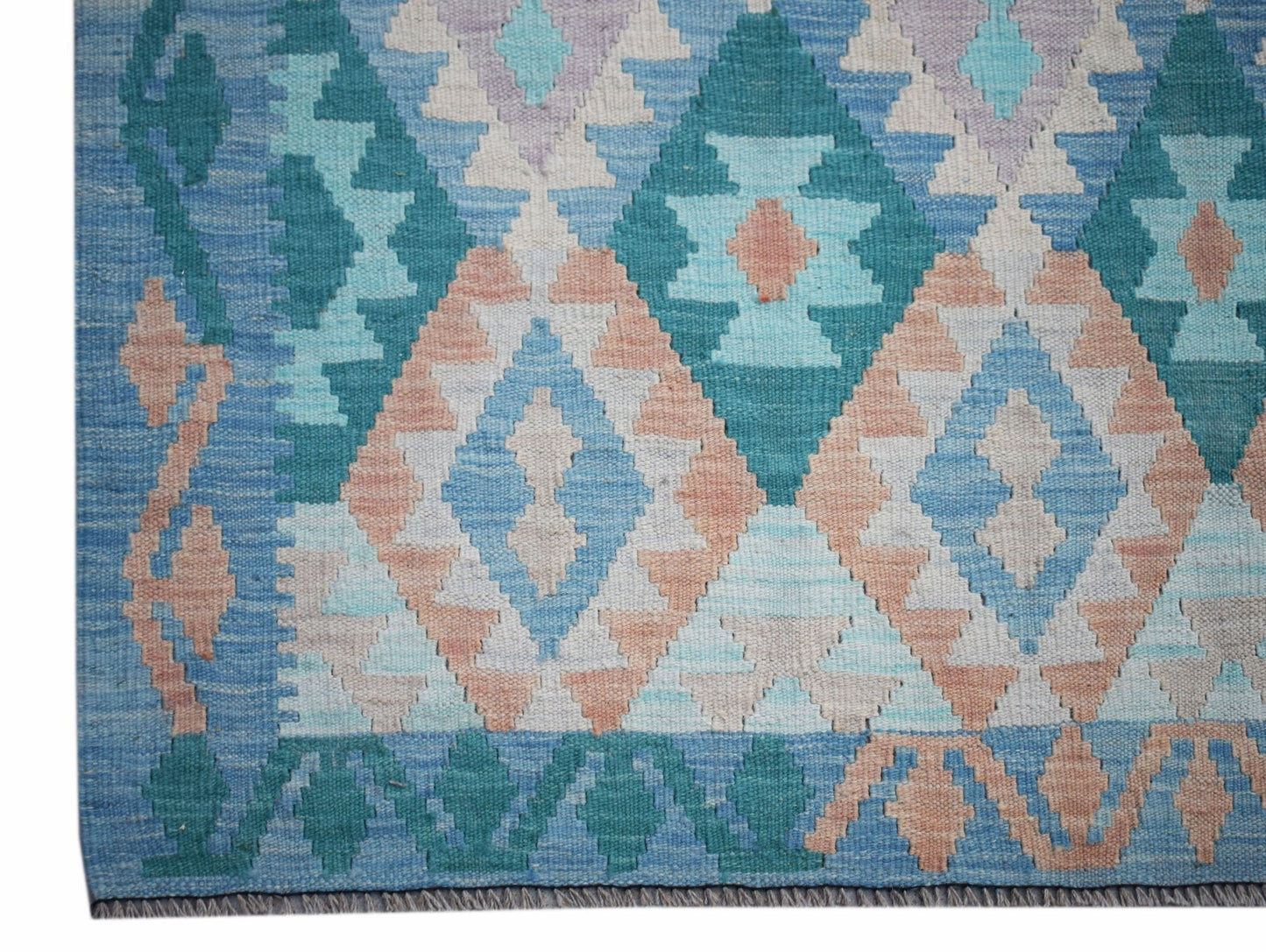 Handwoven Afghan Maimana kilim rug featuring a geometric diamond pattern in blue and peach tones.