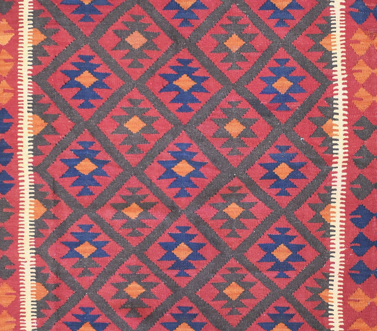 Handmade Afghan Maimana kilim rug featuring a repeating diamond pattern in red, blue, and orange.
