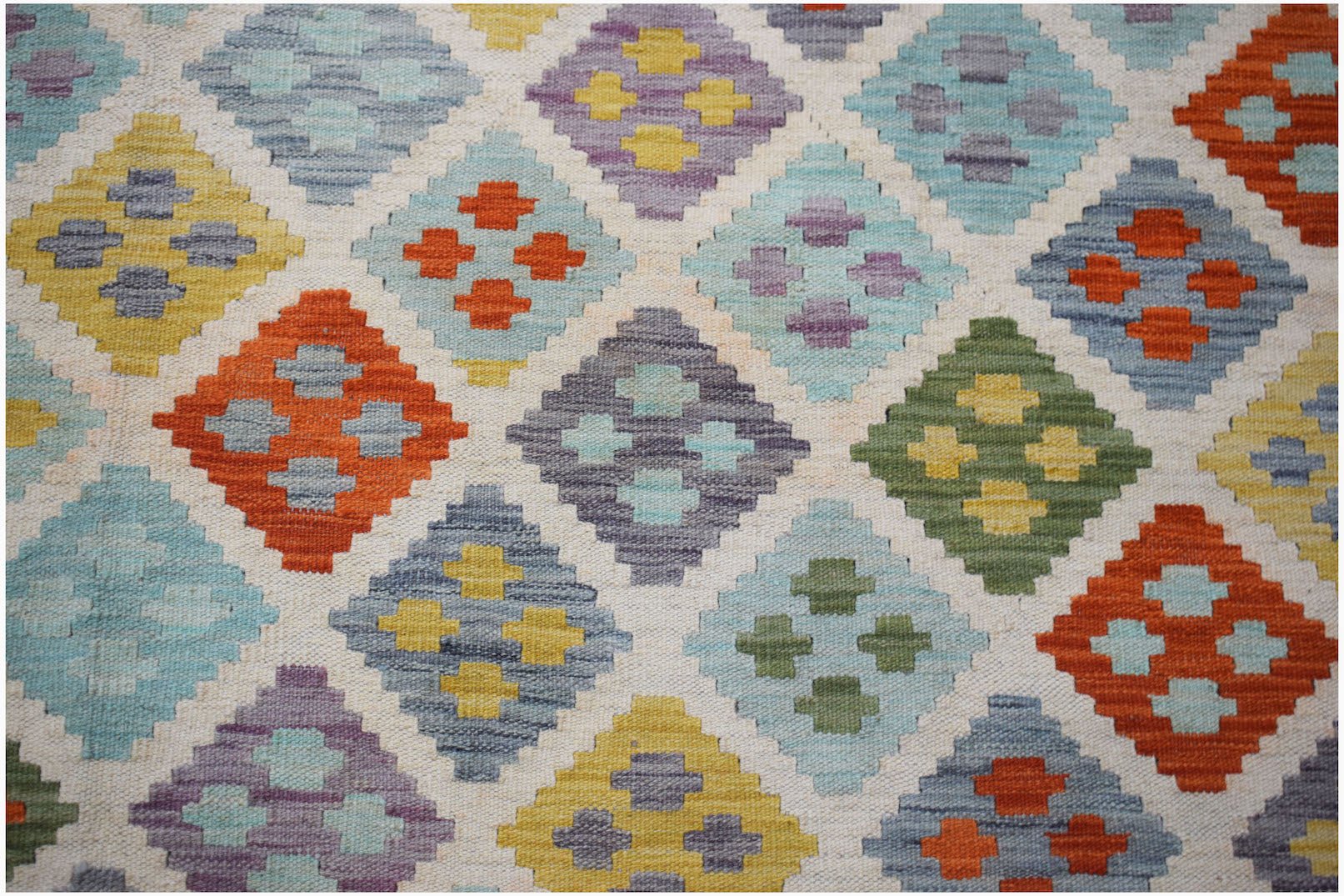 Handwoven Afghan Maimana kilim rug featuring a colorful geometric diamond pattern in wool.