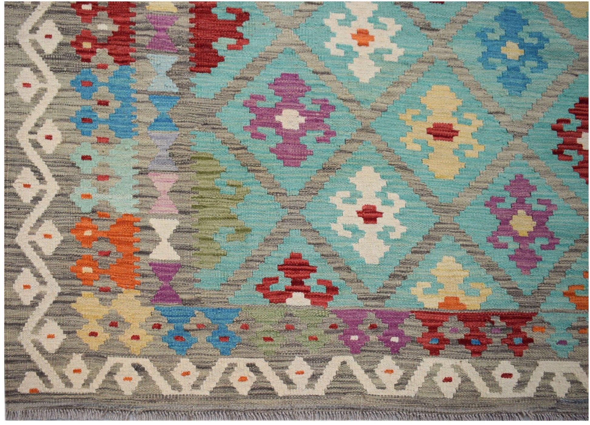 Handwoven Afghan Maimana kilim featuring a geometric diamond pattern in vibrant multicolored wool.