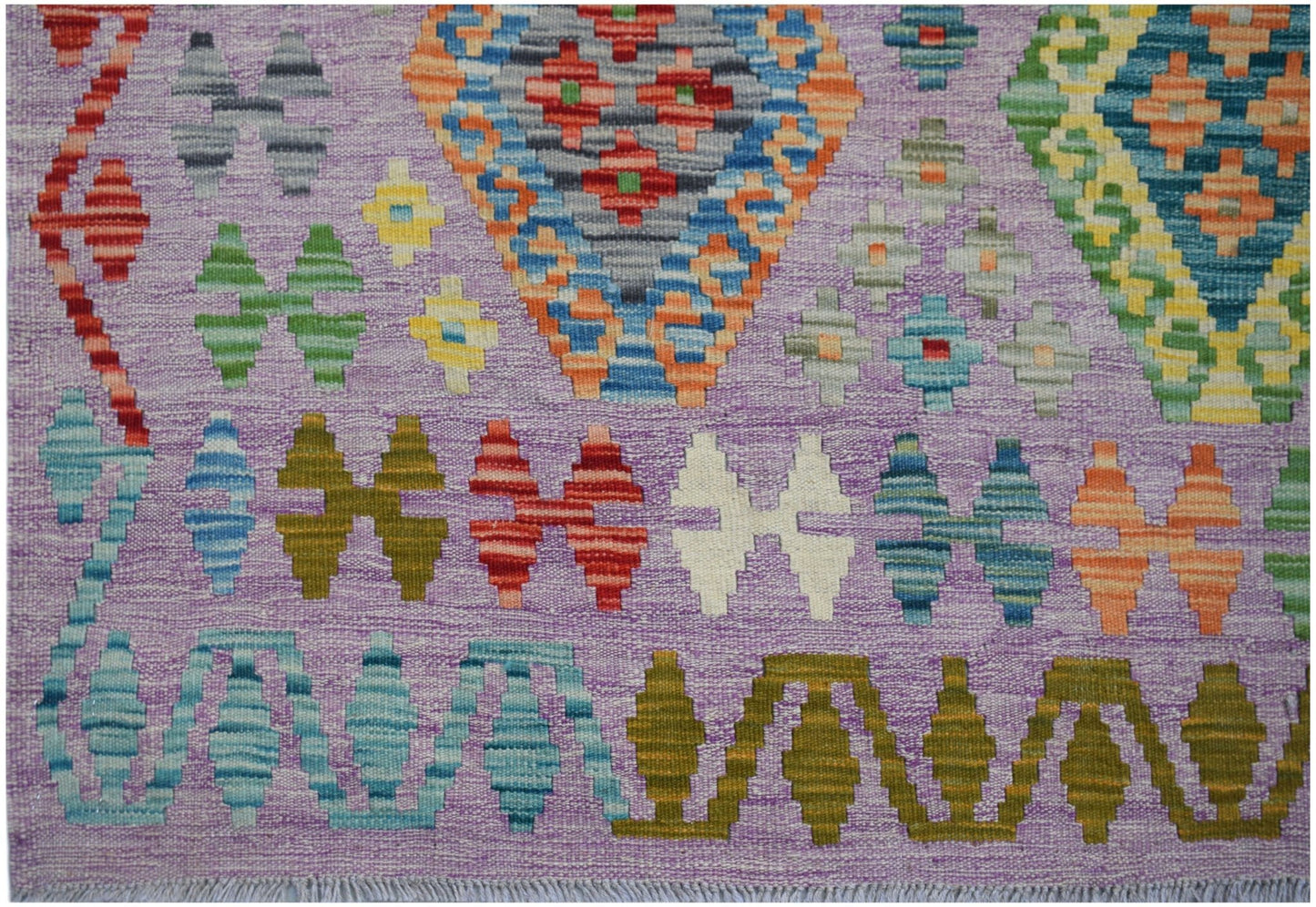 Handwoven Afghan Maimana kilim rug featuring a vibrant geometric pattern on a purple background.