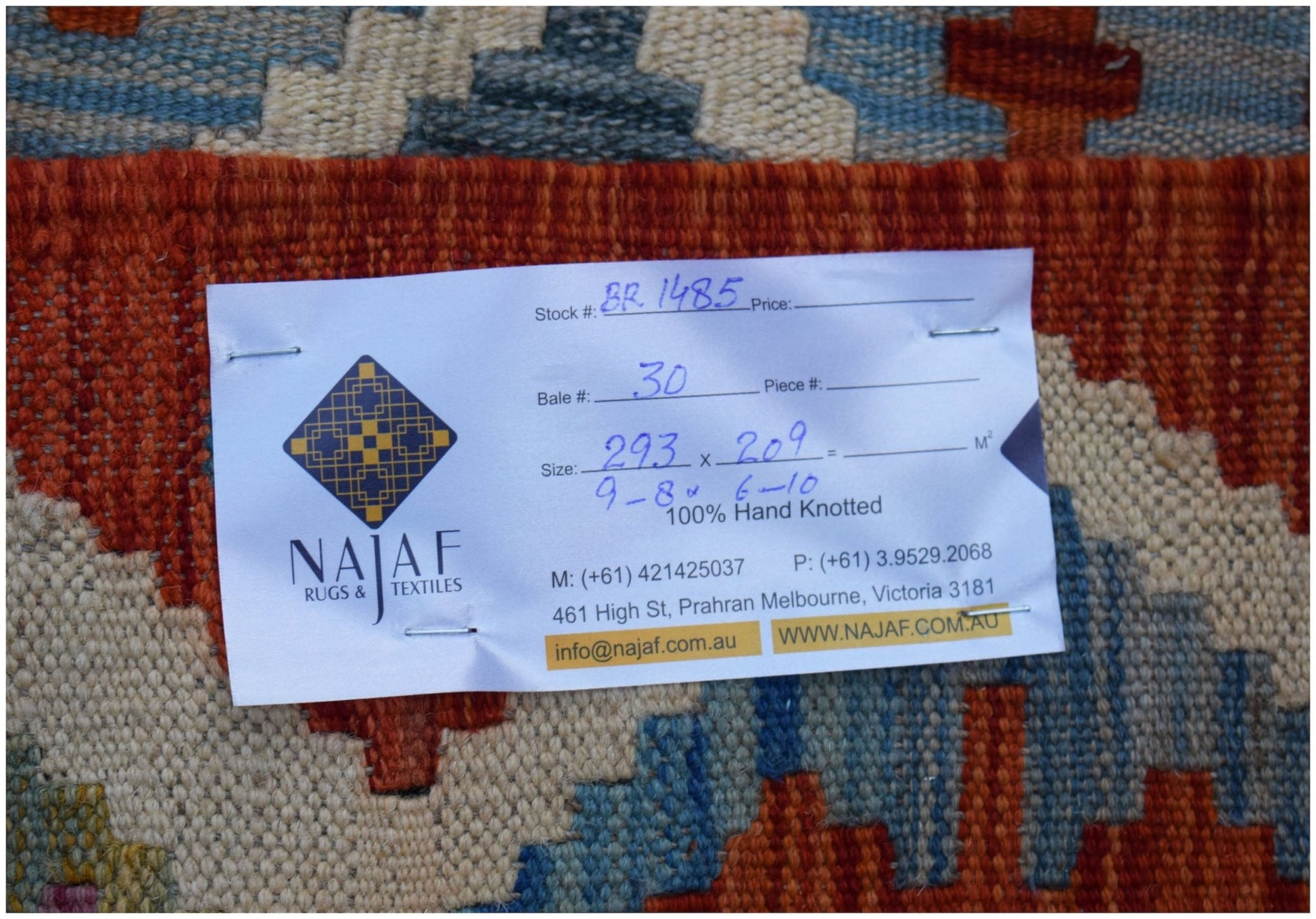 A handwoven Afghan Maimana kilim featuring a geometric pattern in shades of red, blue, and cream.
