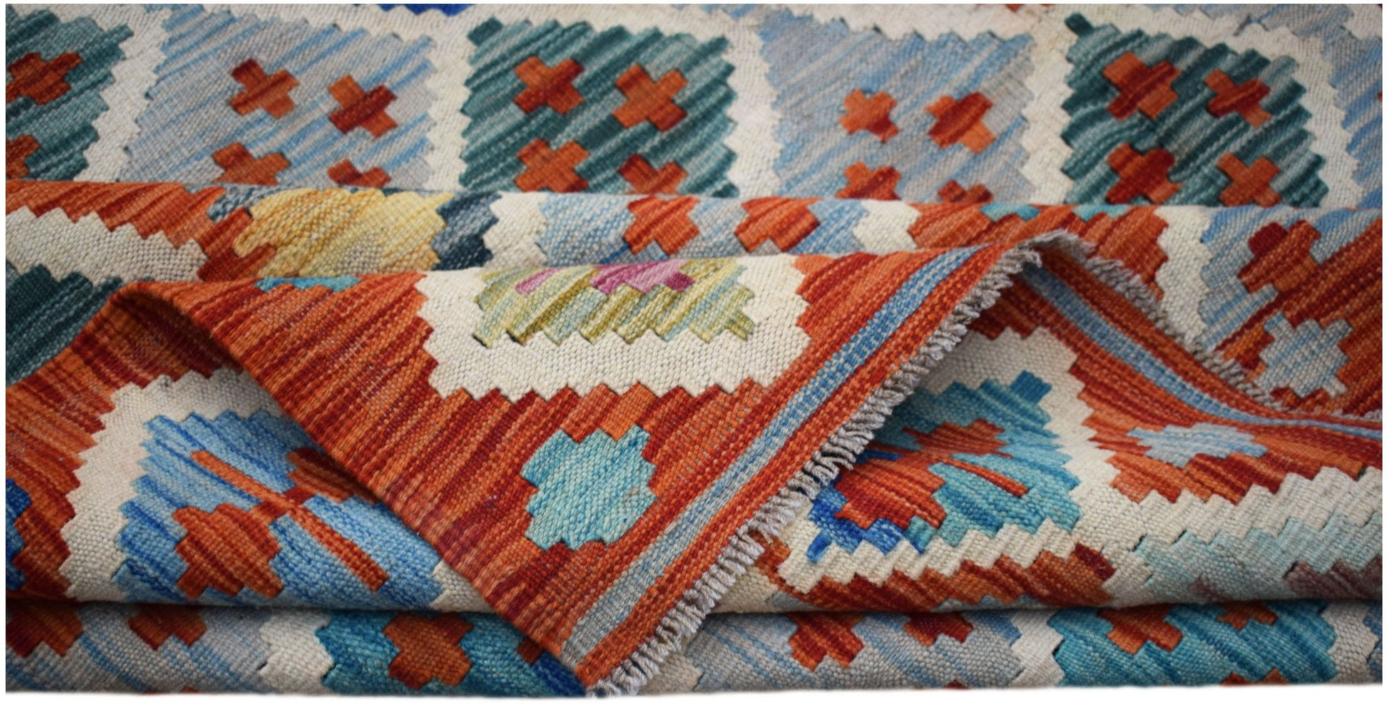 A handwoven Afghan Maimana kilim rug featuring a geometric pattern in orange, blue, and cream.