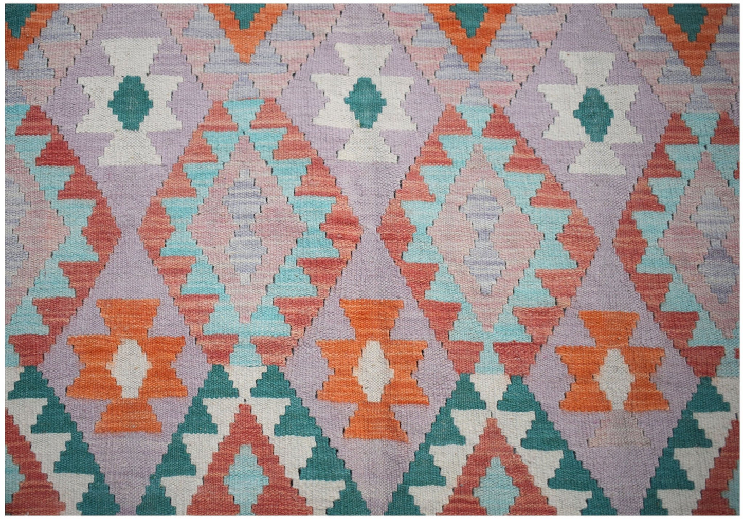Handwoven Afghan Maimana kilim featuring a geometric diamond pattern in vibrant multicolored wool.