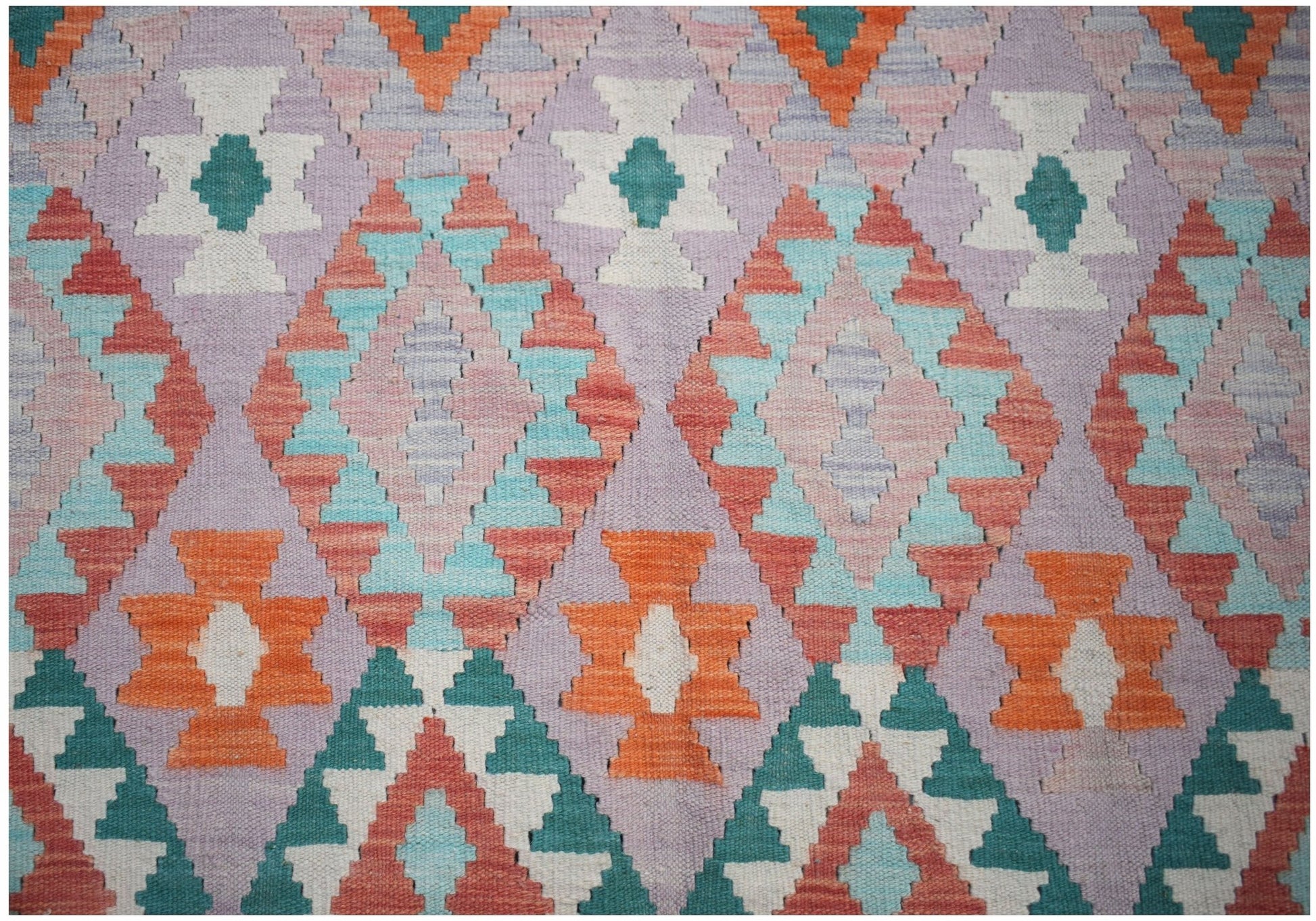Handwoven Afghan Maimana kilim featuring a geometric diamond pattern in vibrant multicolored wool.