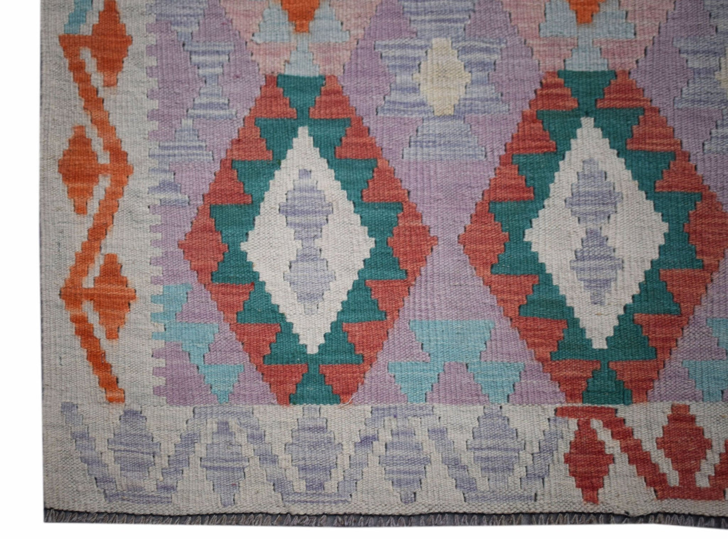 Handwoven Afghan Maimana kilim rug featuring a geometric diamond pattern in vibrant wool colors.