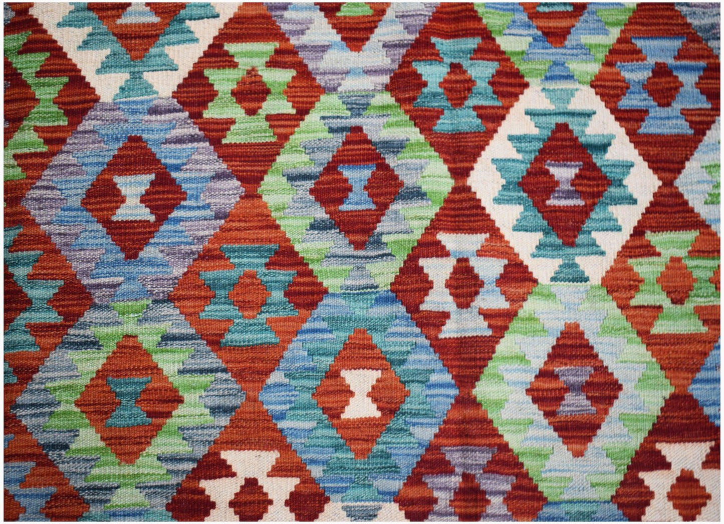 Handwoven Afghan Maimana kilim featuring a vibrant geometric diamond pattern in wool.
