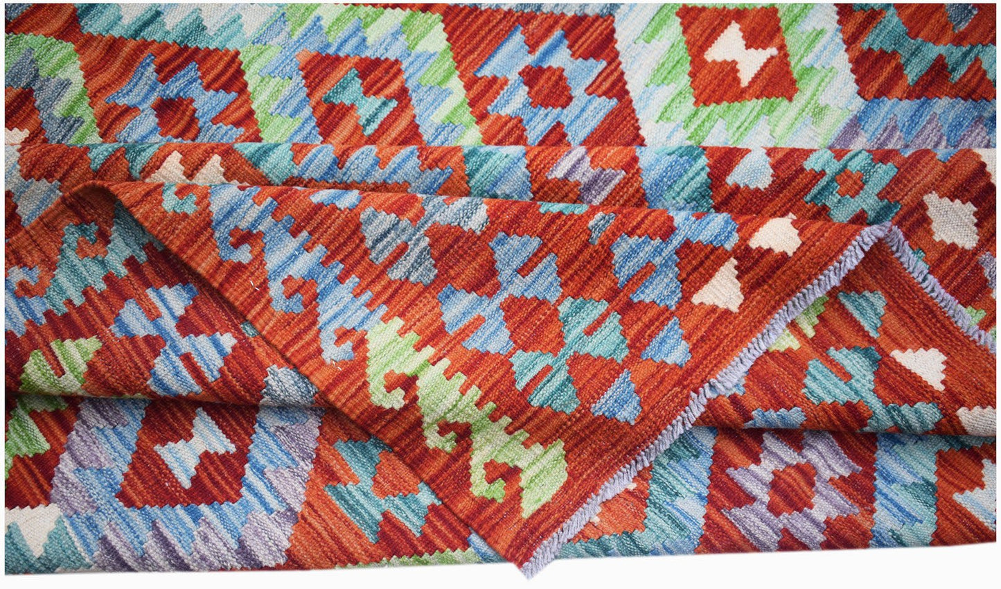Handwoven Afghan Maimana kilim rug featuring a vibrant geometric pattern in wool.