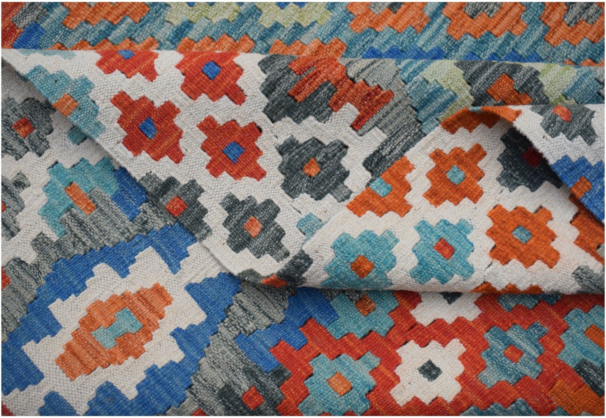 Handwoven Afghan Maimana kilim rug featuring a colorful geometric pattern in wool.
