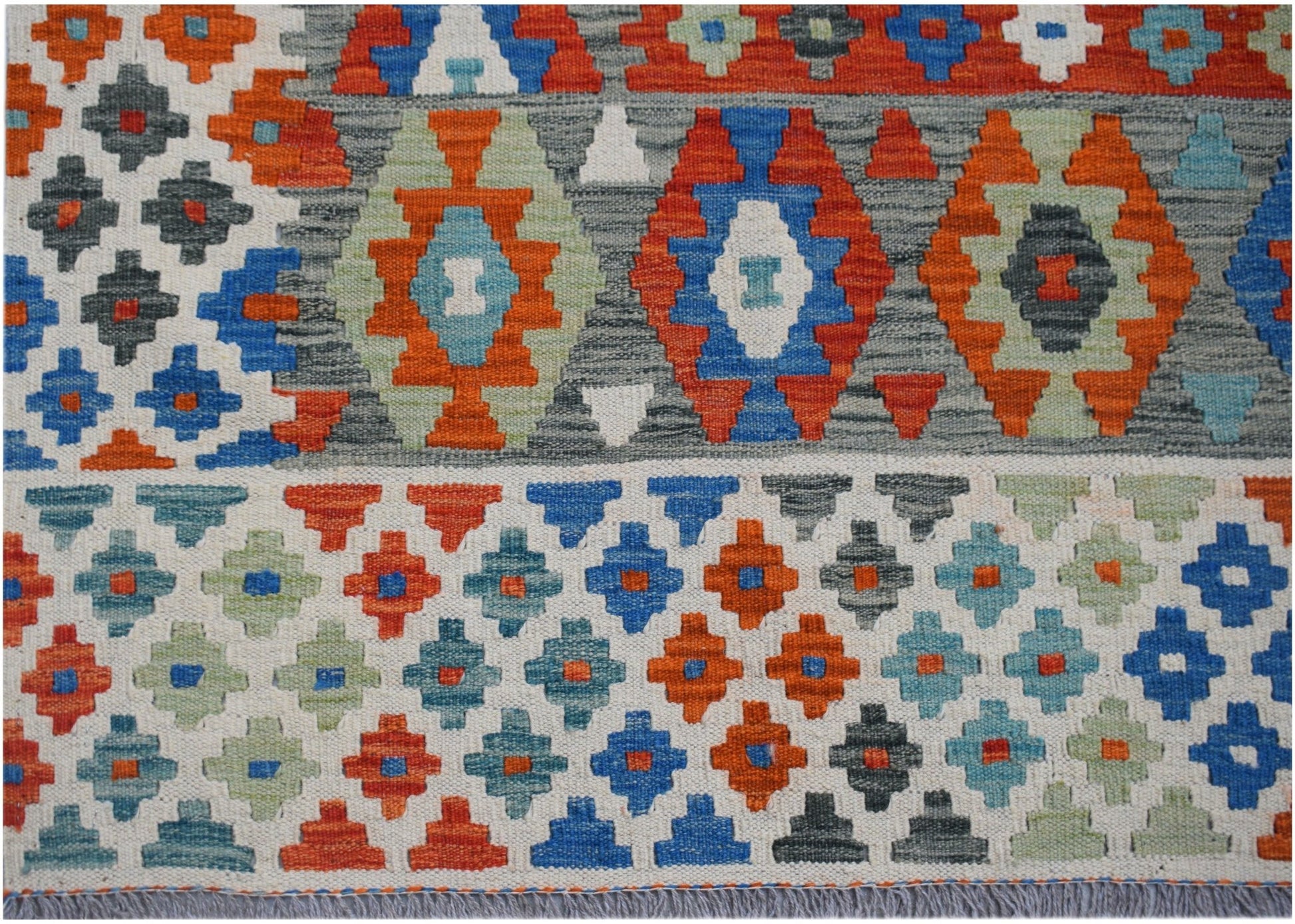 Handwoven Afghan Maimana kilim featuring a geometric pattern in vibrant orange, blue, and green.