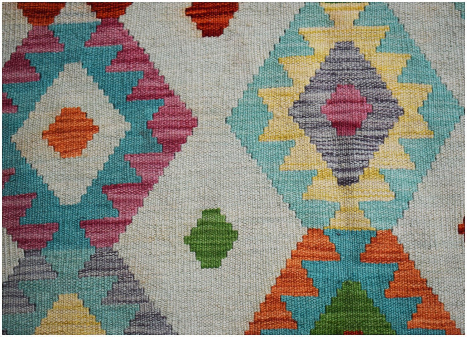 Handwoven Afghan Maimana kilim rug featuring a colorful geometric diamond pattern on a cream base.