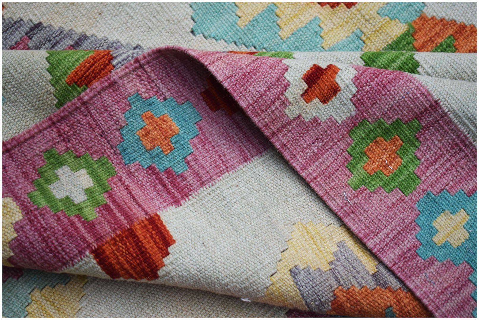 Handwoven Afghan Maimana kilim rug featuring a colorful geometric pattern on a flatweave wool base.