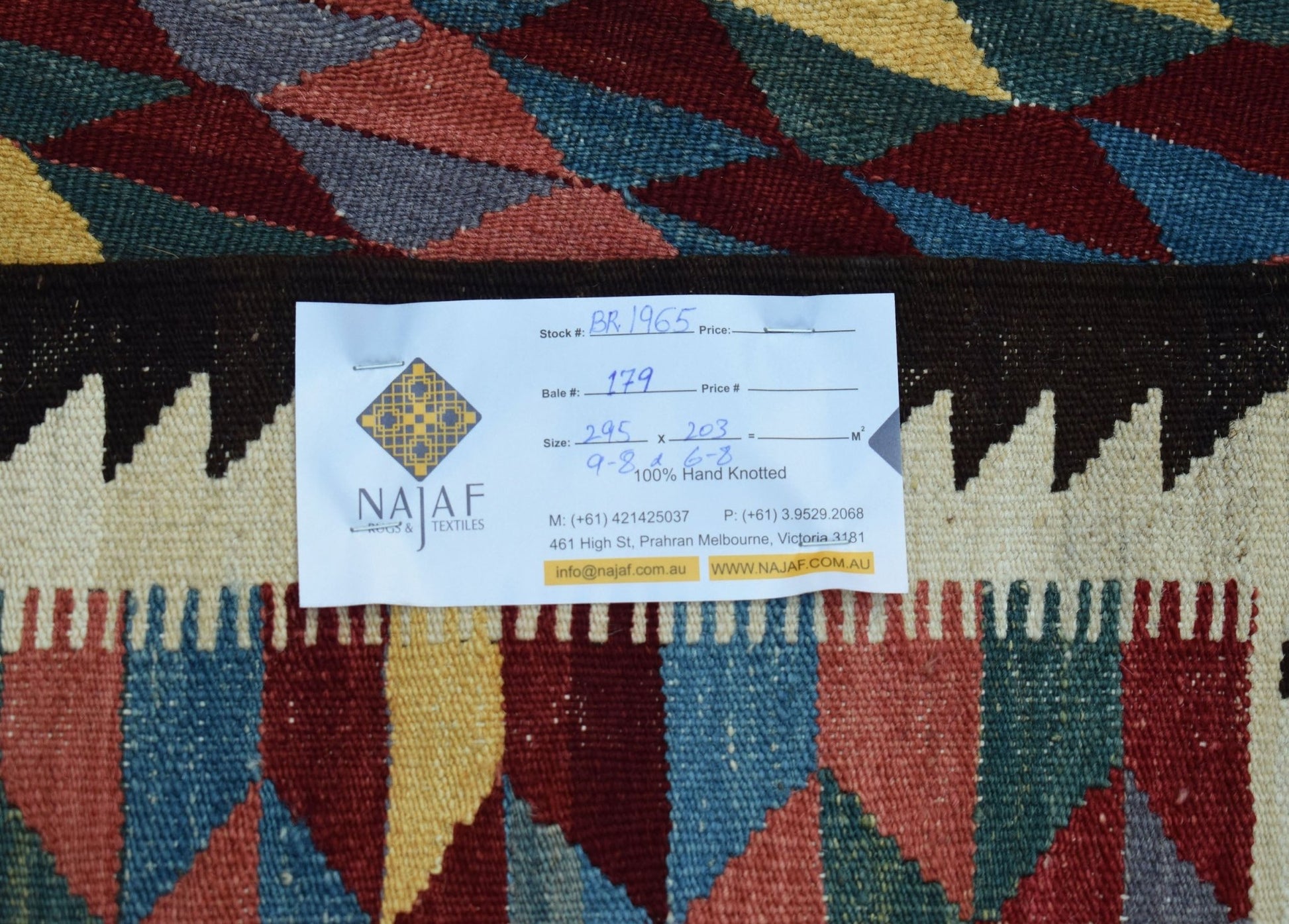 An Afghan Maimana kilim rug featuring a geometric diamond pattern in red, blue, and yellow.
