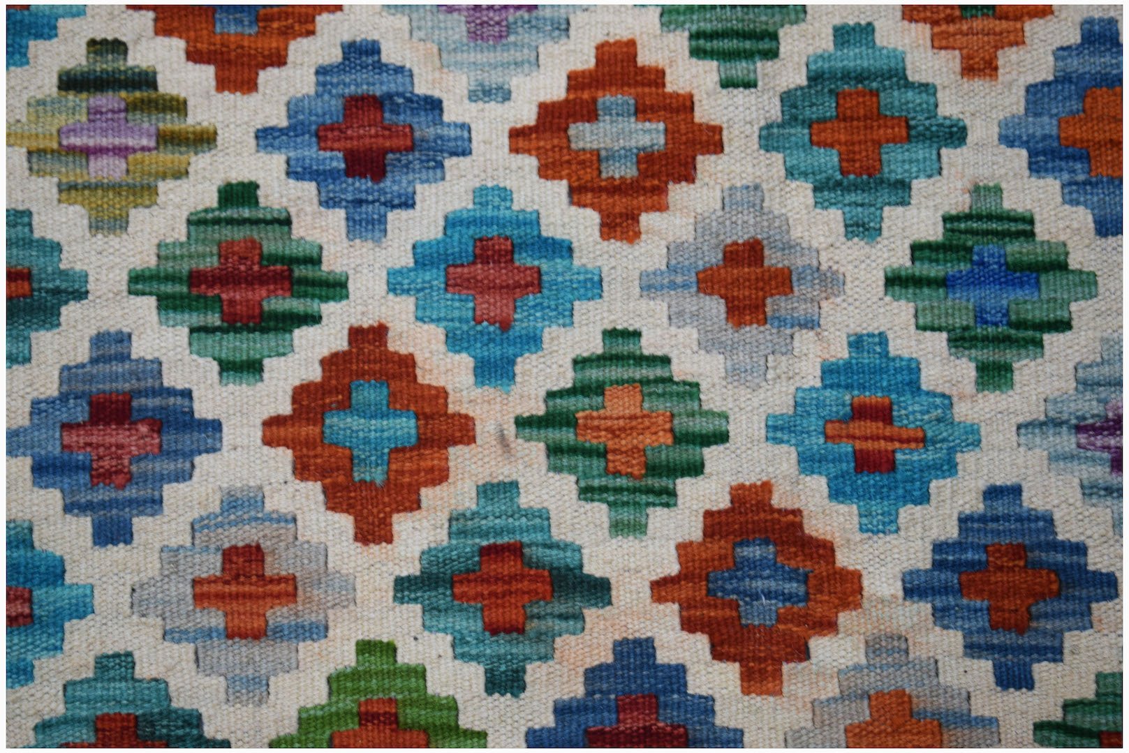 Handwoven Afghan Maimana kilim featuring a repeating geometric diamond pattern in vibrant colors.