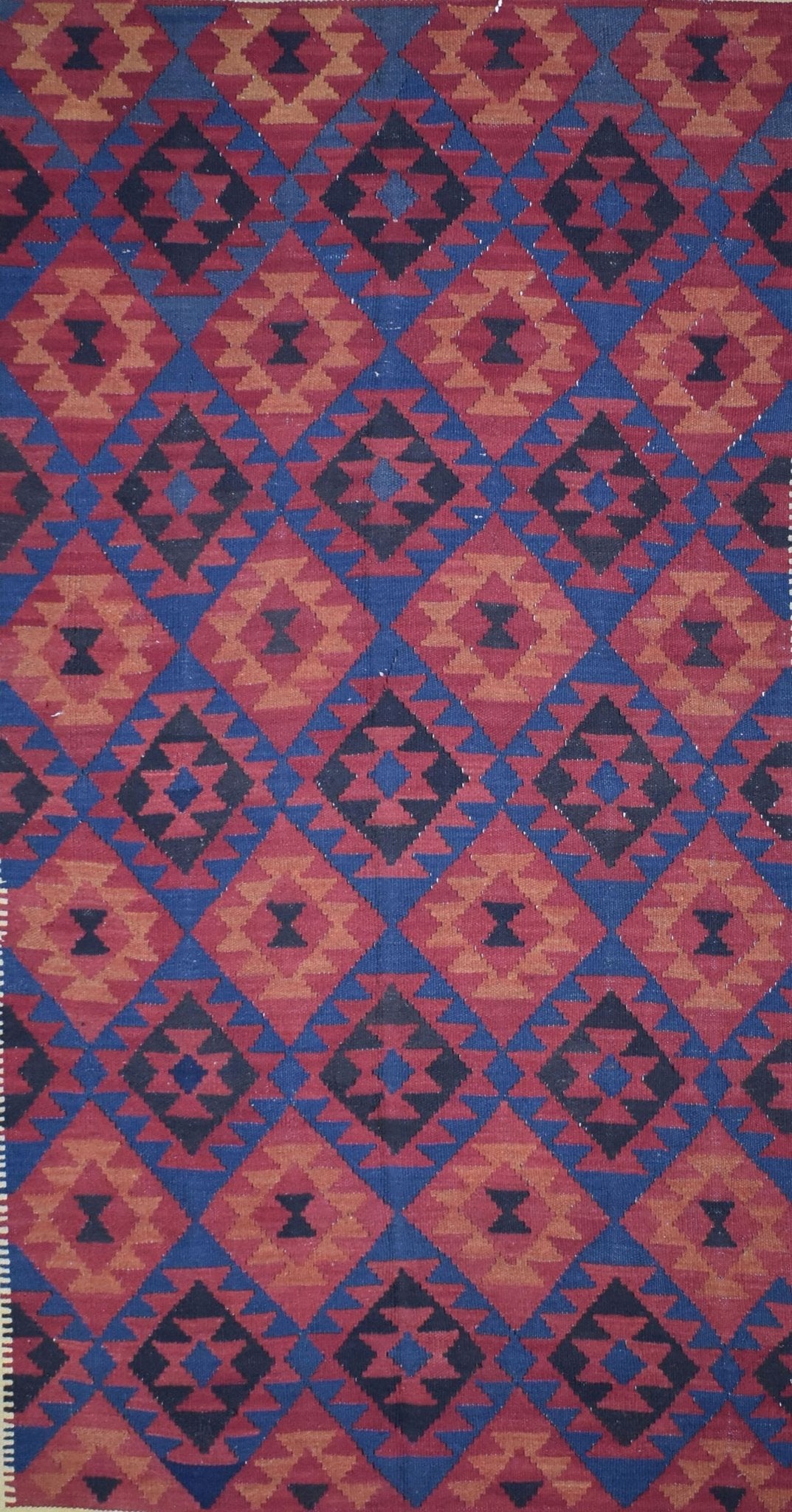 Handmade Afghan Maimana kilim rug featuring a repeating geometric diamond pattern in red and blue.