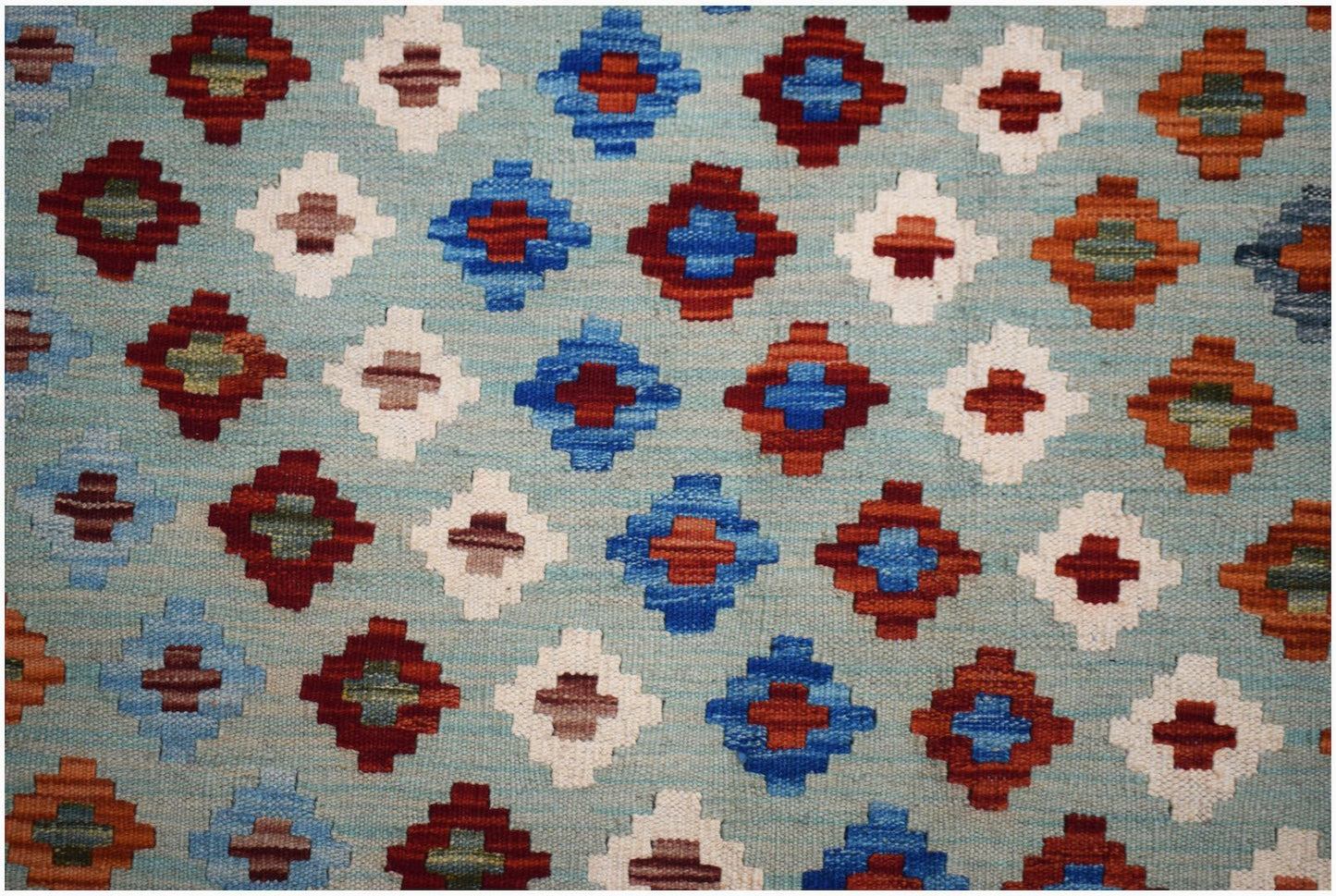 Handwoven Afghan Maimana kilim featuring a repeating geometric diamond pattern in vibrant colors.