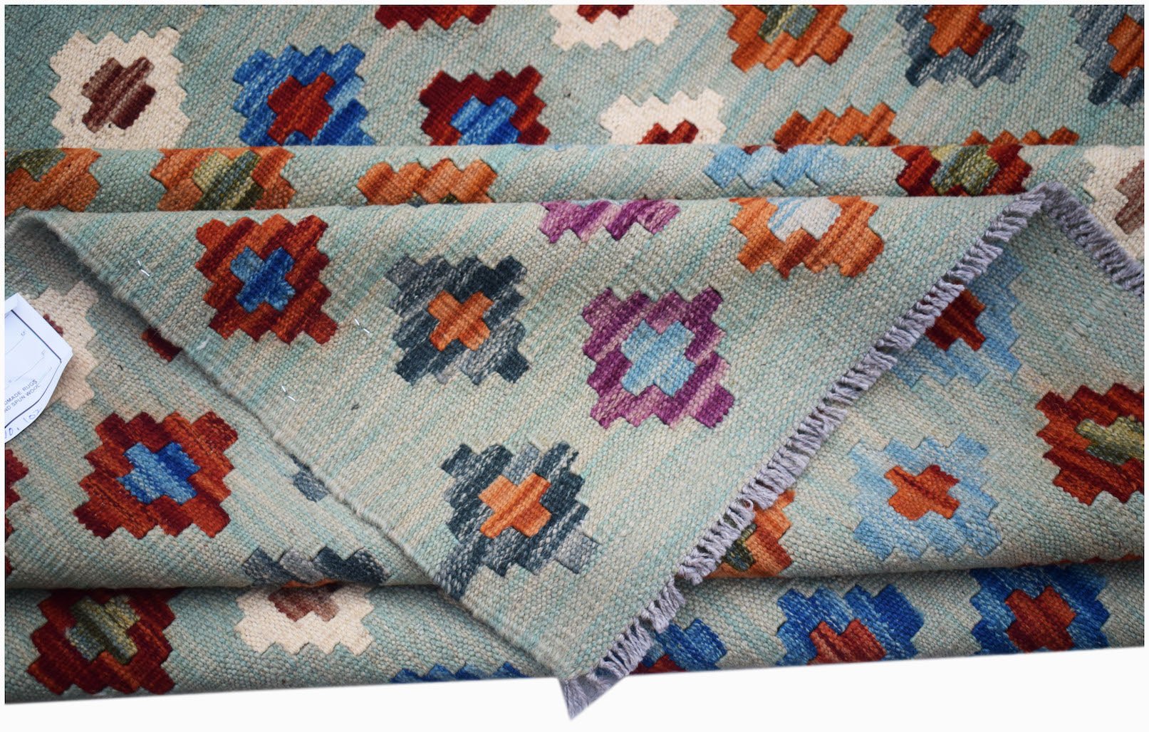 Handwoven Afghan Maimana kilim rug featuring a light blue background with geometric motifs.