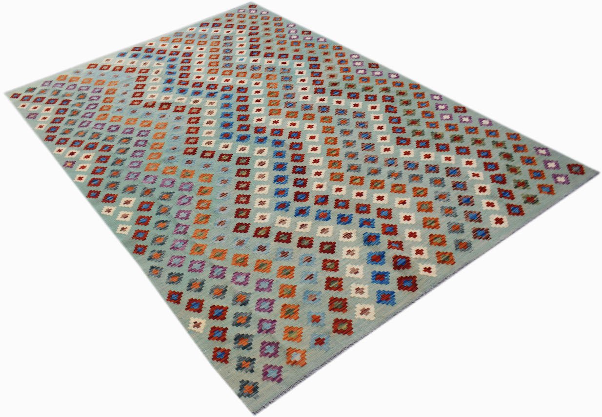 A handmade Afghan Maimana kilim rug featuring a light blue background with colorful geometric motifs.