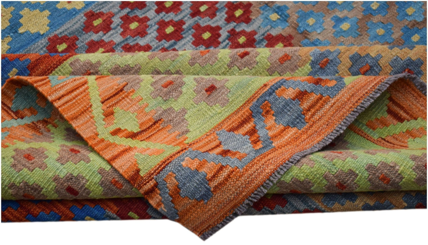 A handwoven Afghan Maimana kilim rug featuring colorful geometric patterns in a flatweave texture.