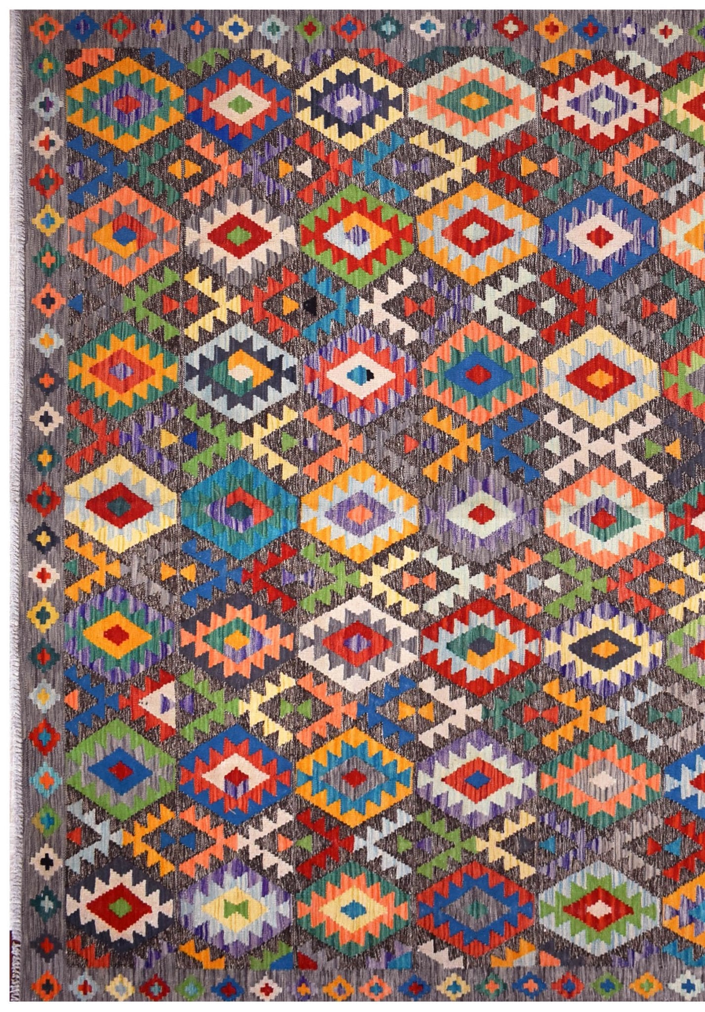 Handmade Afghan Maimana kilim rug featuring a vibrant geometric diamond pattern on a grey background.
