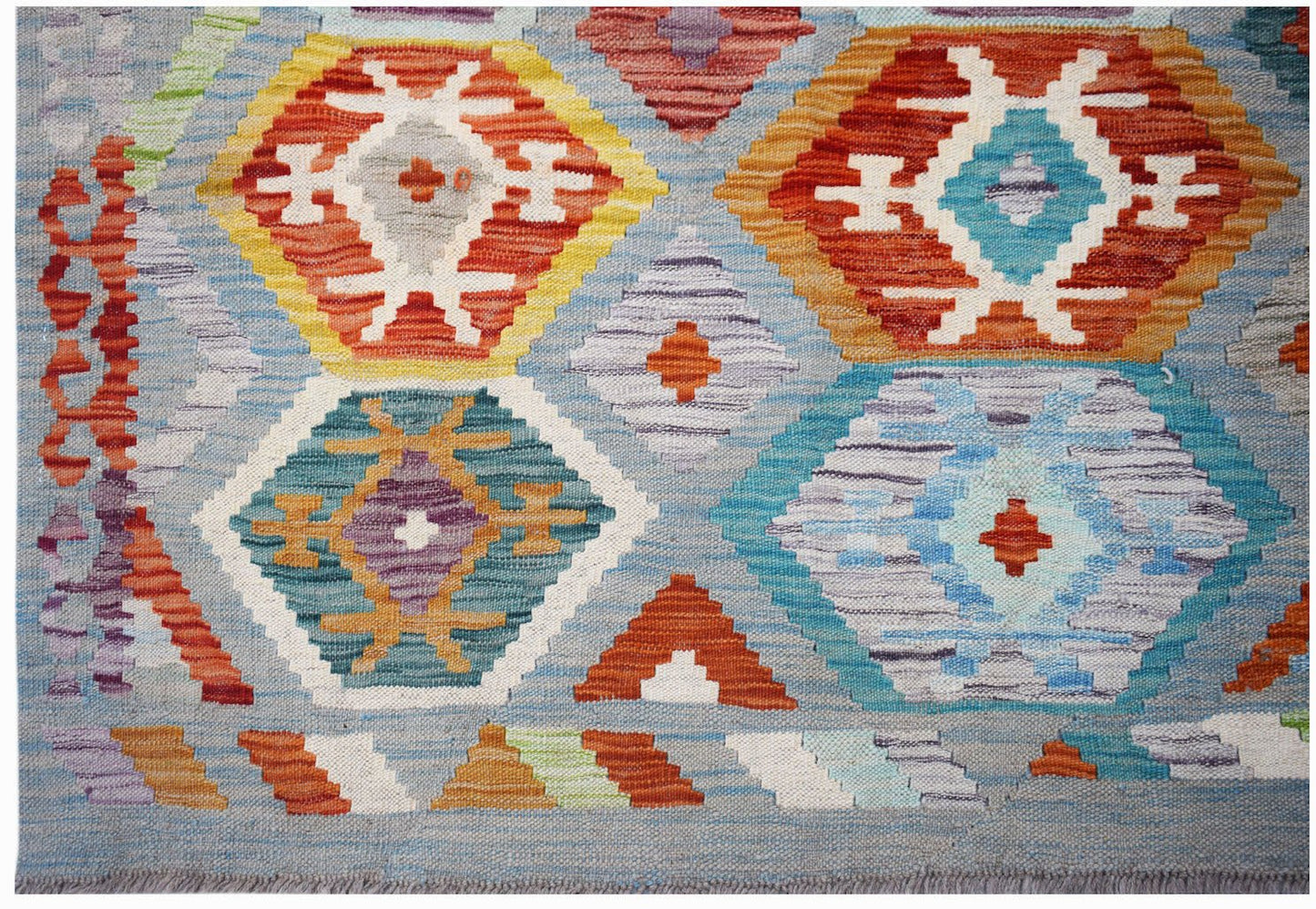 Handwoven Afghan Maimana kilim rug featuring a geometric pattern in vibrant multicolored hues.