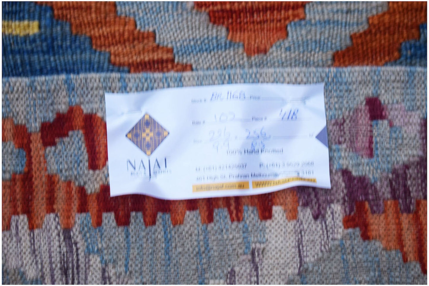 A handwoven Afghan Maimana Kilim featuring a vibrant geometric pattern in wool.