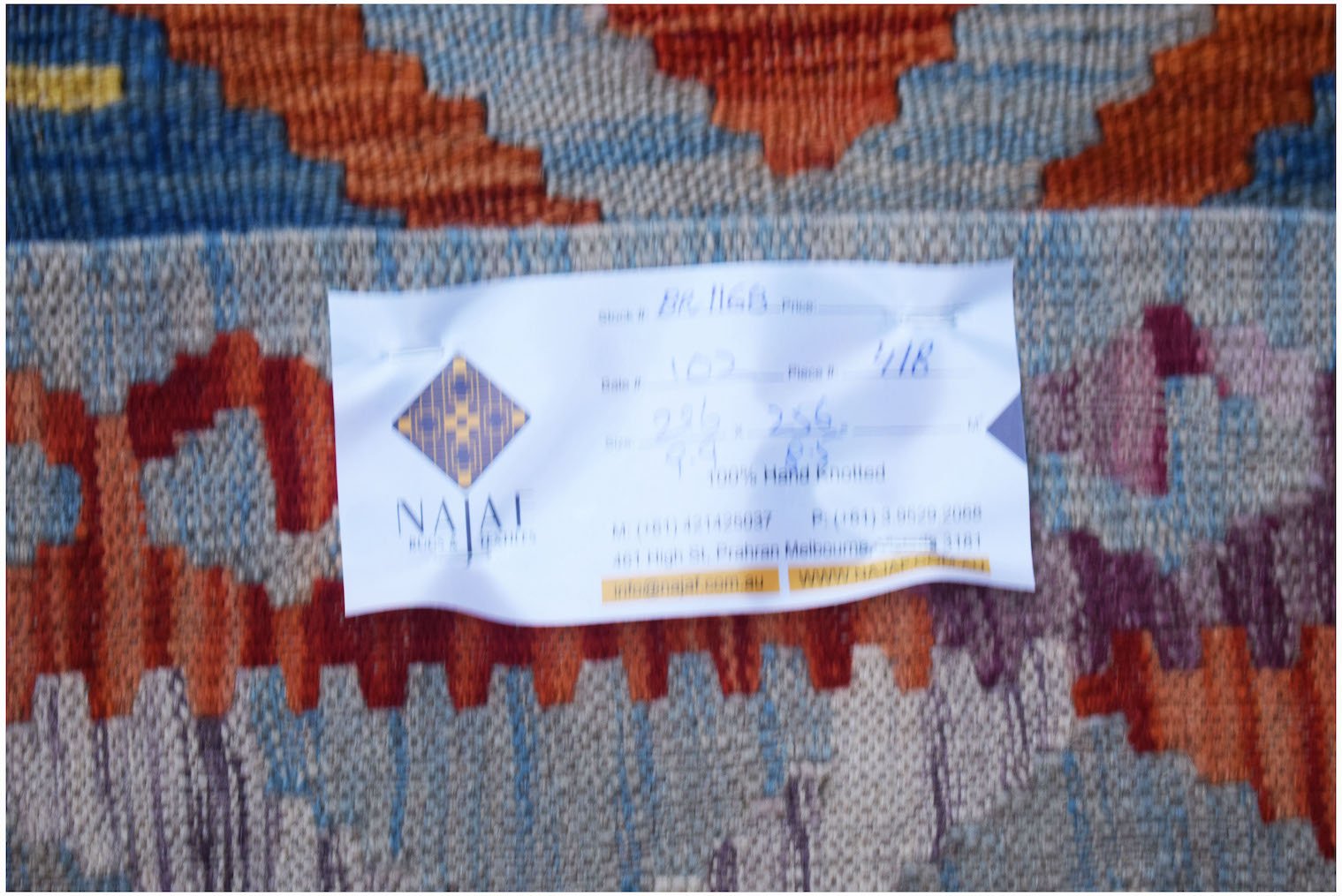 A handwoven Afghan Maimana Kilim featuring a vibrant geometric pattern in wool.