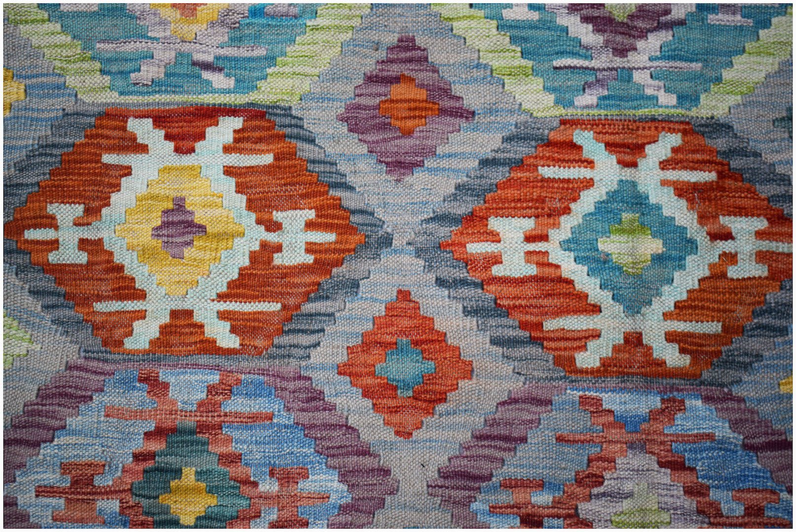 Afghan Maimana Kilim with geometric patterns in red, blue, yellow, and purple.