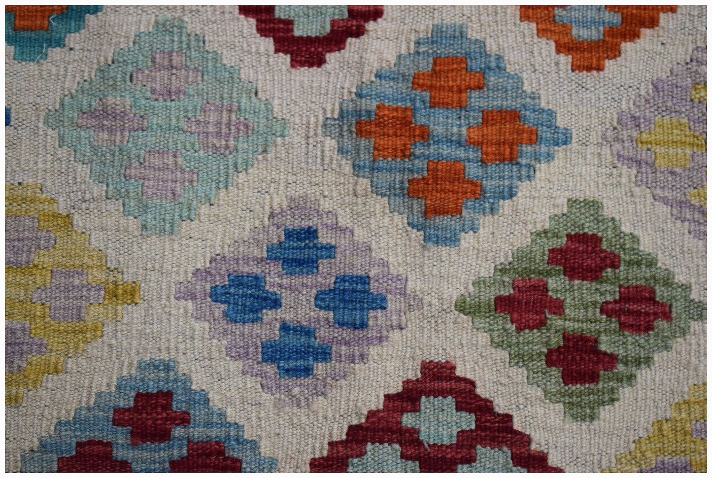 Handwoven Afghan Maimana kilim featuring a repeating geometric diamond pattern in vibrant colors.