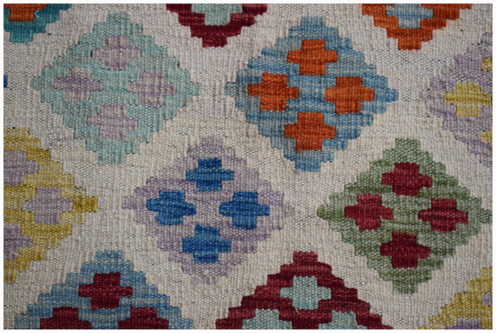 Handwoven Afghan Maimana kilim featuring a repeating geometric diamond pattern in vibrant colors.