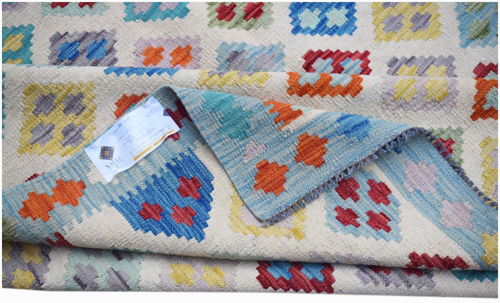 Handwoven Afghan Maimana kilim rug featuring a colorful geometric pattern on a cream background.