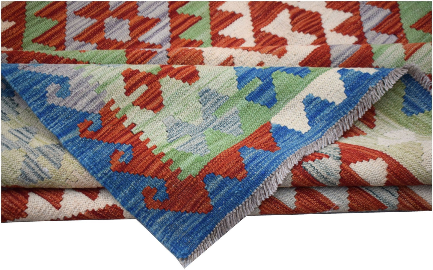 A handmade Afghan Maimana kilim rug featuring a geometric pattern in blue, green, and orange wool.
