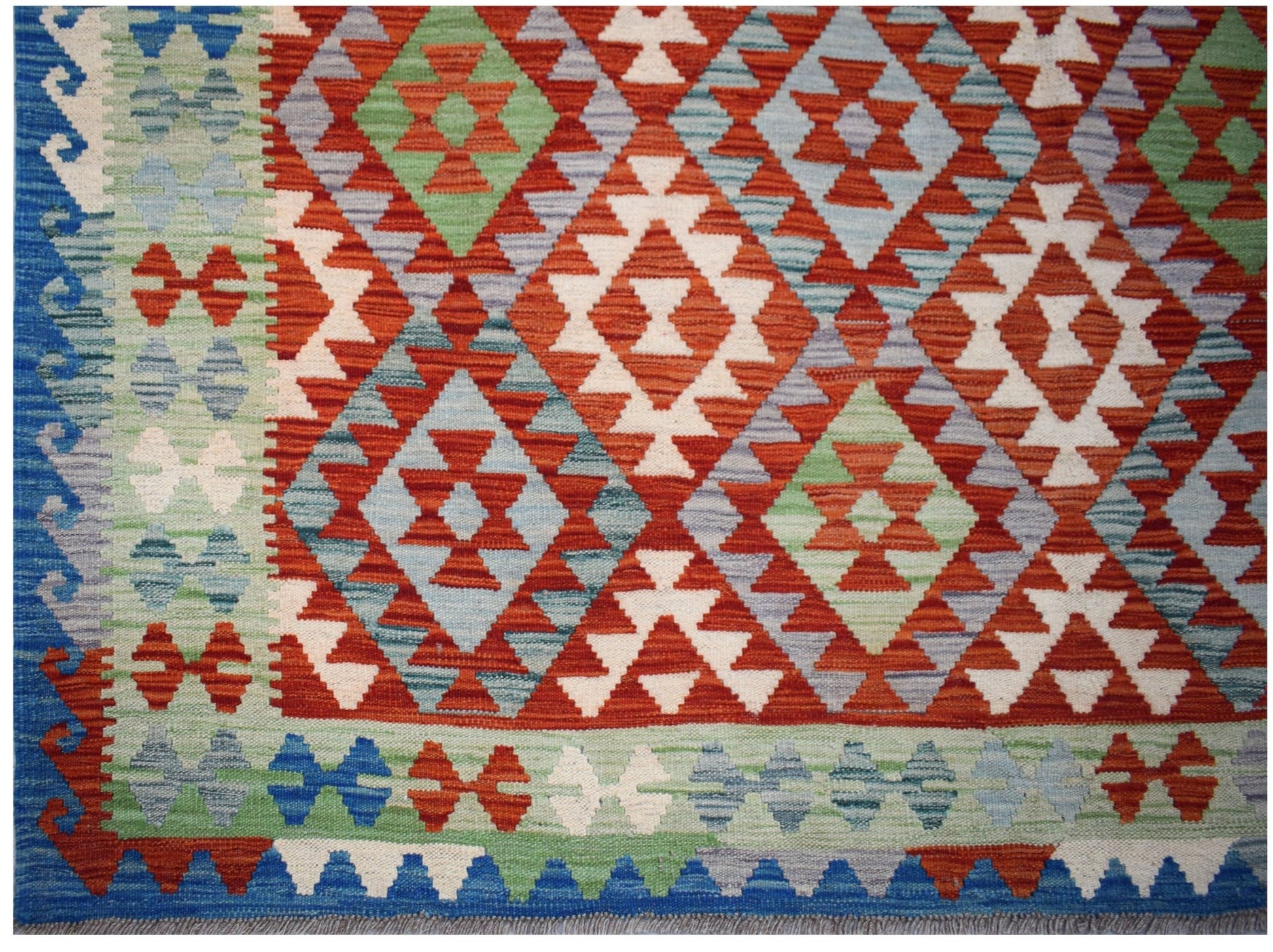 Handwoven Afghan Maimana kilim rug featuring a geometric diamond pattern in red, blue, and green.