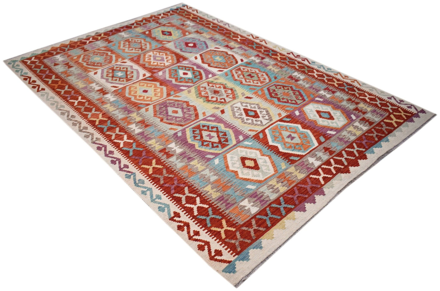 Handwoven Afghan Maimana kilim rug featuring a colorful geometric pattern on a flat wool weave.