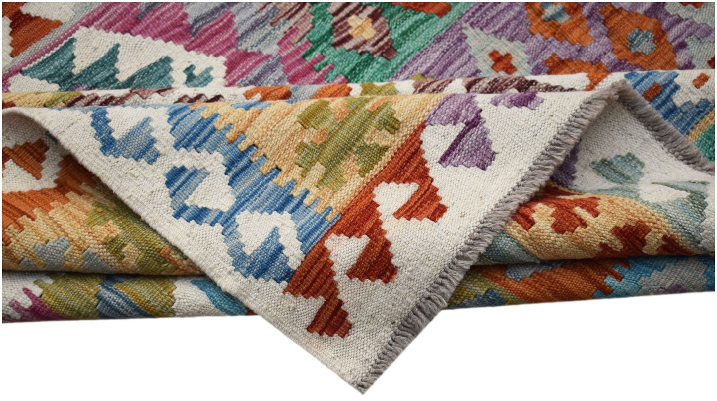 A handwoven Afghan Maimana kilim rug featuring a vibrant, multicolored geometric pattern.