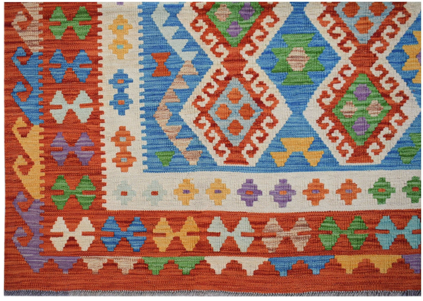 Handwoven Afghan Maimana kilim featuring a vibrant geometric pattern in wool.