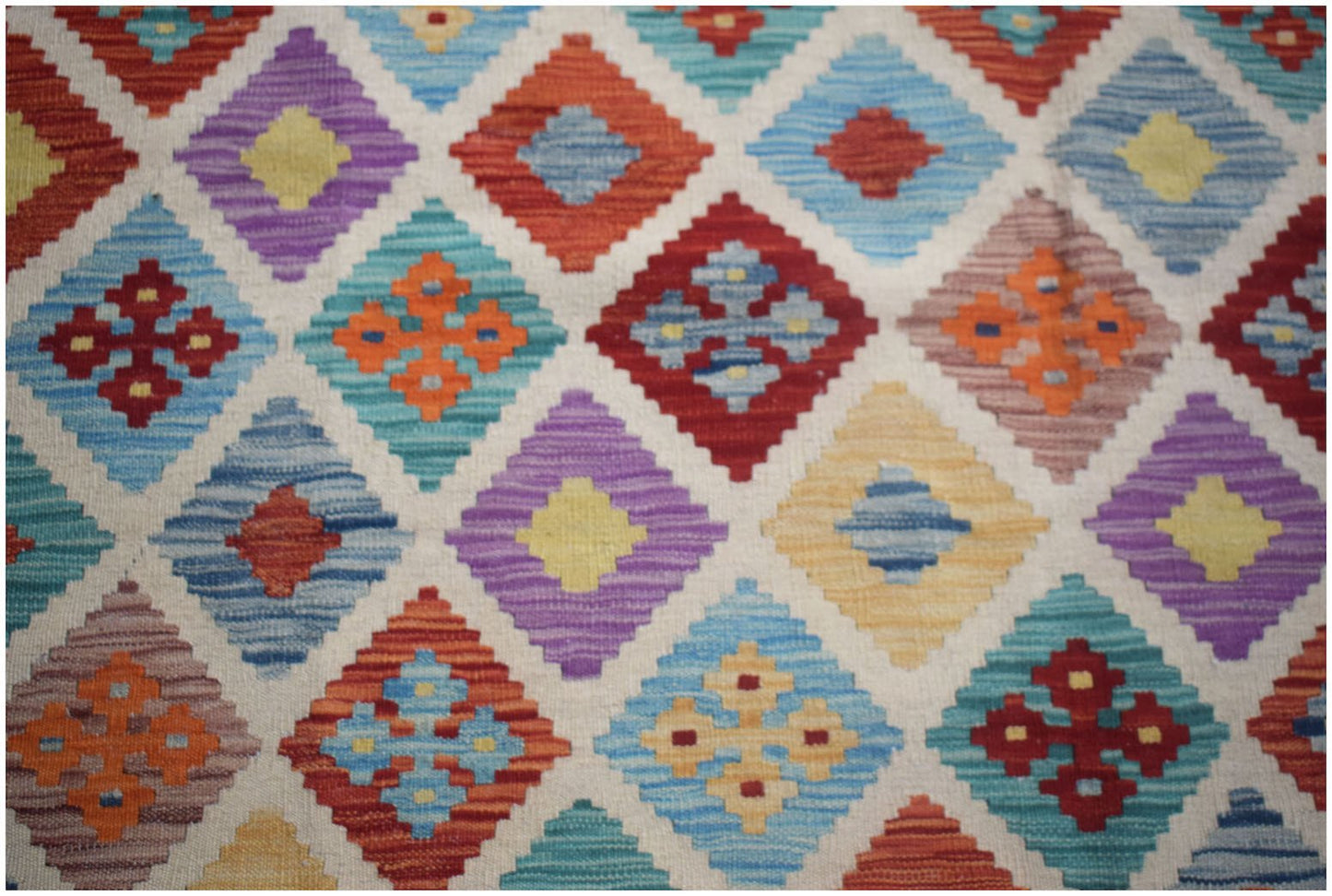 Handwoven Afghan Maimana kilim rug featuring a colorful geometric diamond pattern in wool.