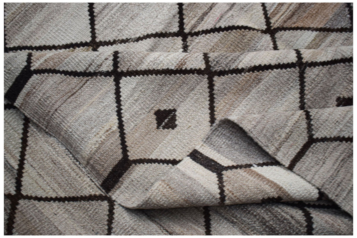 A handmade Afghan Maimana kilim featuring a neutral geometric grid pattern with small dark accents.